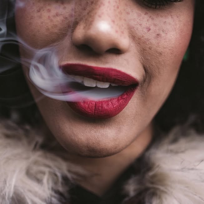 Her Stixx brand artwork with smoke and deep red lipstick